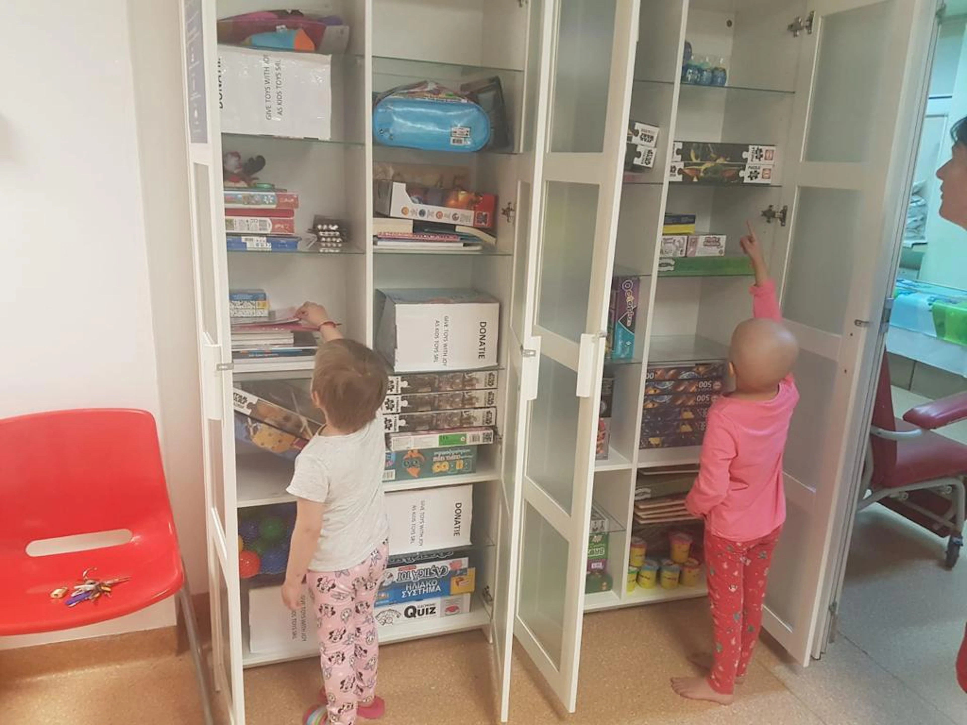 Copii internați în oncologia pediatrică aleg jocuri din dulapul cu jucării