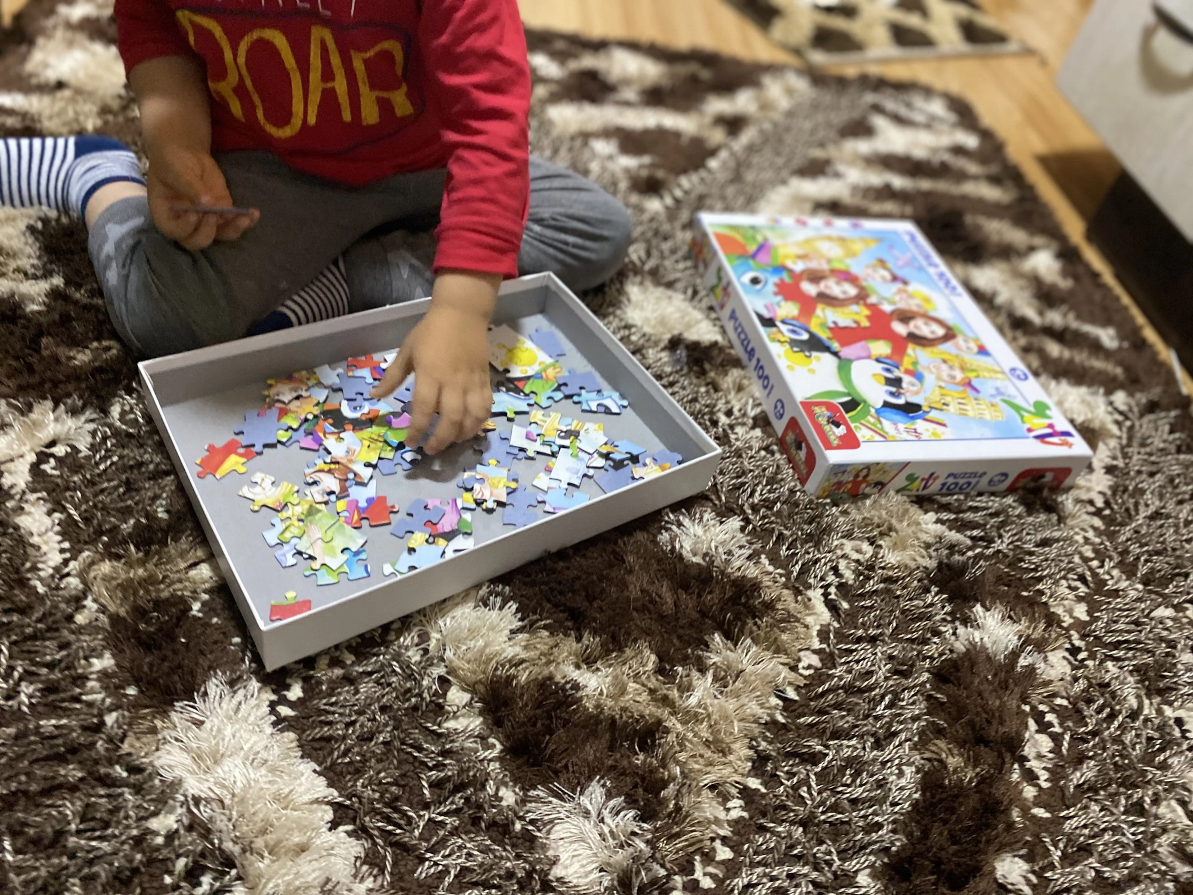 Copil care asamblează un puzzle primit prin campanie