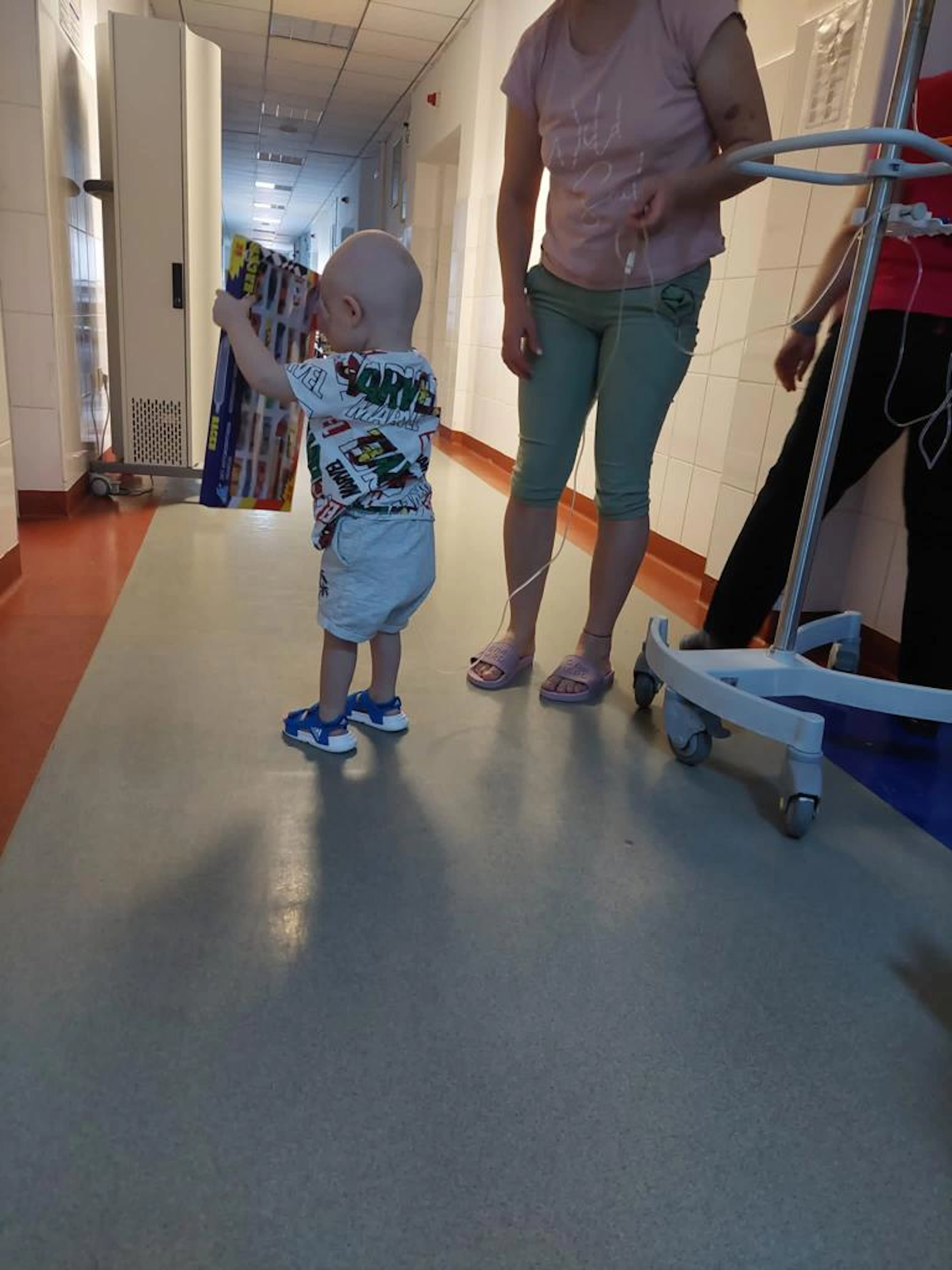 Mic pacient pe holul secției, cu o jucărie primită prin campanie